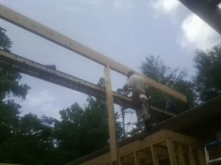 Carpenter setting a ridge beam over a new addition frame — Ice Dam Removal by Roofing Brothers in Round Rock