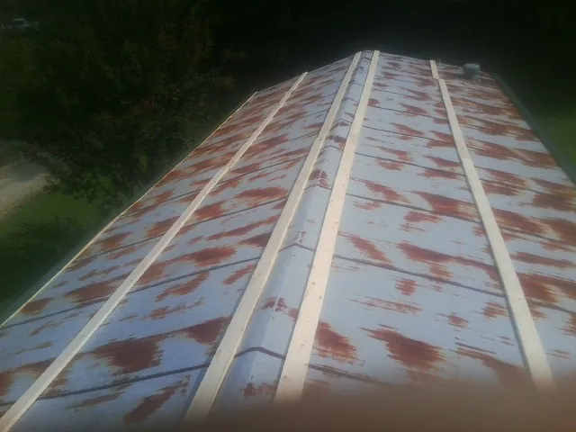 Rusted metal roof panels with new wood purlins before replacement — Storm Damage Roof Repair in Round Rock by Roofing Brothers