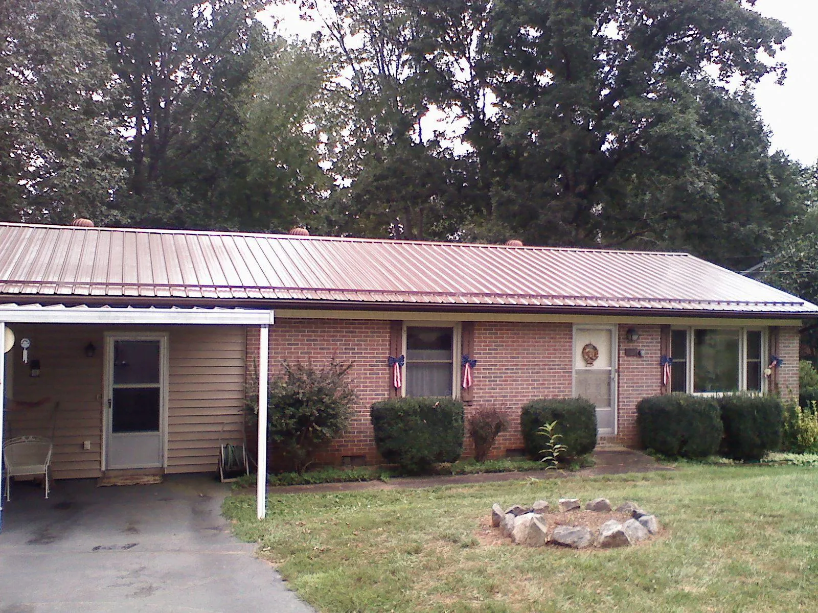 Bronze metal roof and carport on a brick ranch home — Roof Repair work by our crew in Round Rock