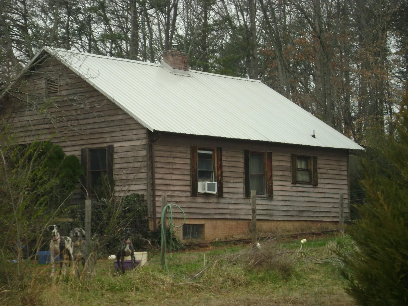 White metal roof on an old wood sided farmhouse, from a Metal Roof Installation job in Round Rock